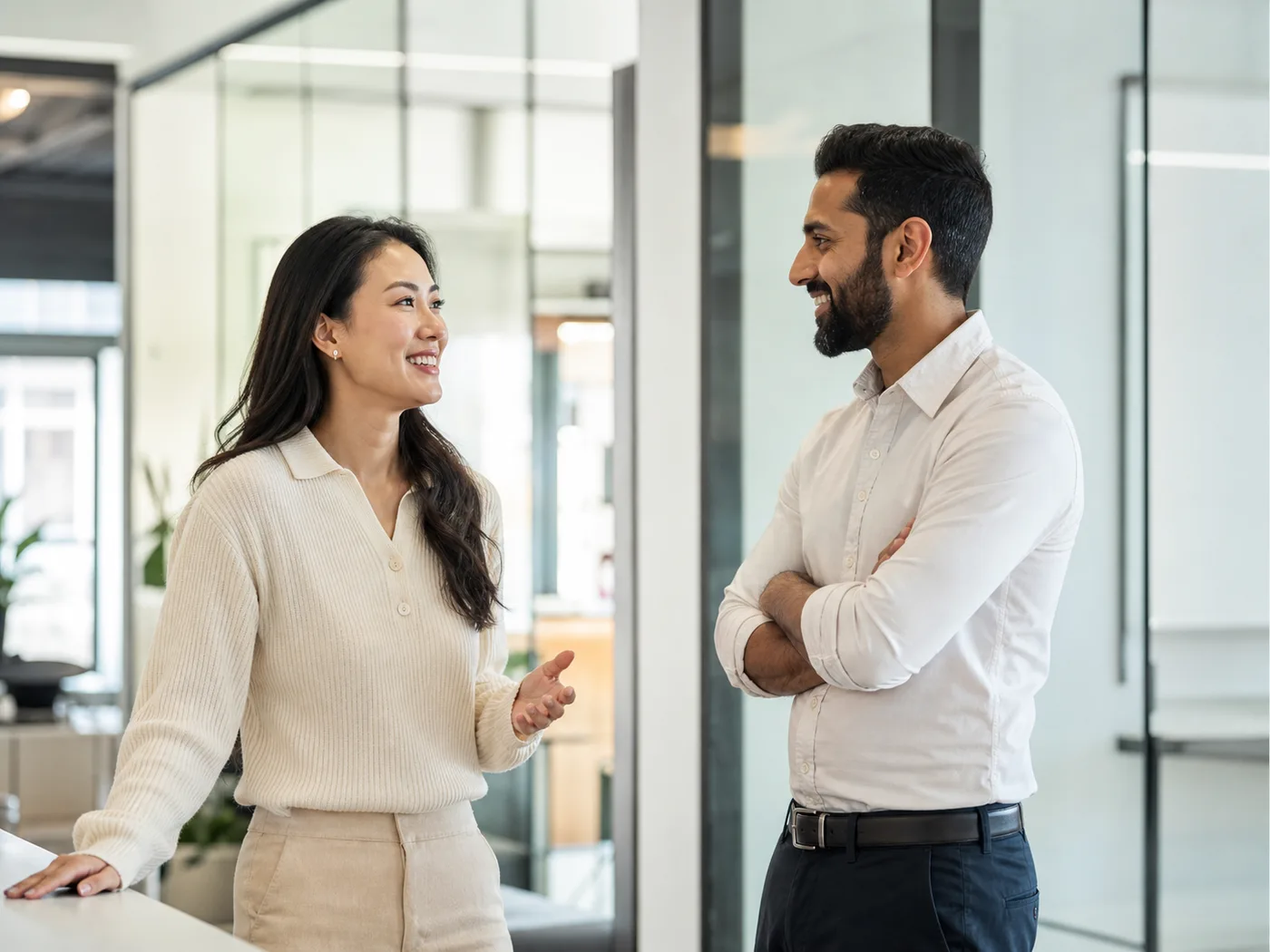 Two professionals having a friendly conversation in a bright modern software office